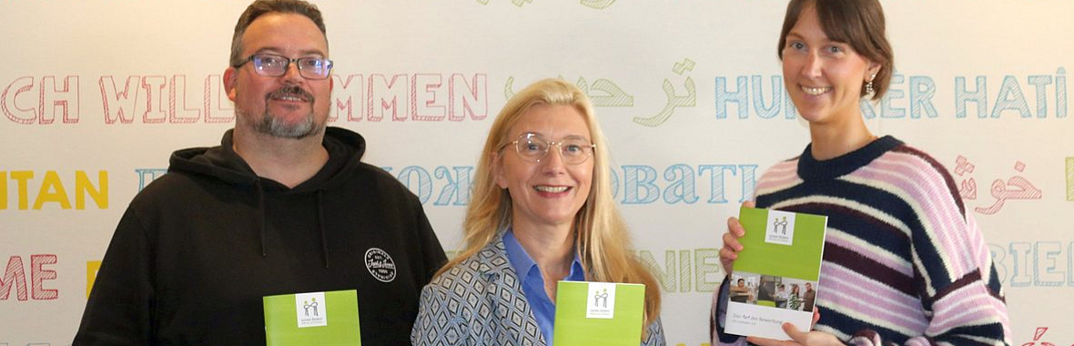 Drei Personen halten das neue 1x1 hoch. 
