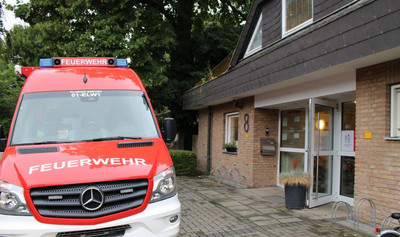 Es steht ein Feuerwehrfahrzeug vor der Eingangstür der Kita