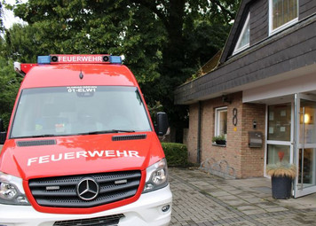 Es steht ein Feuerwehrfahrzeug vor der Eingangstür der Kita