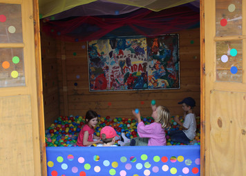 4 Kinder sitzen im Bällebad und spielen.