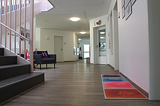 Der Eingangsbereich auf Kinderhöhe. Rechts die Treppe, davor das Elterncafe und rechts Ein bunter Weg für die Kinder