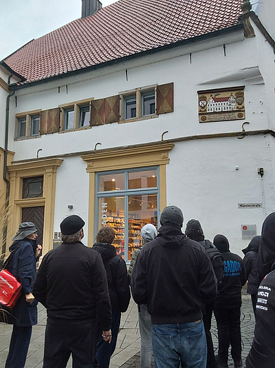 Eine Gruppe Personen stehen vor einem Haus