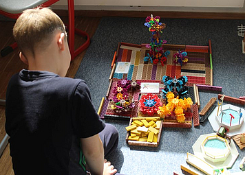 Kind spielt mit verschiedenen Baumaterialien