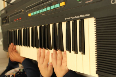 Kinderhände spielen Keyboard.