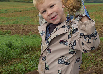 Junge mit Kartoffel in der Hand