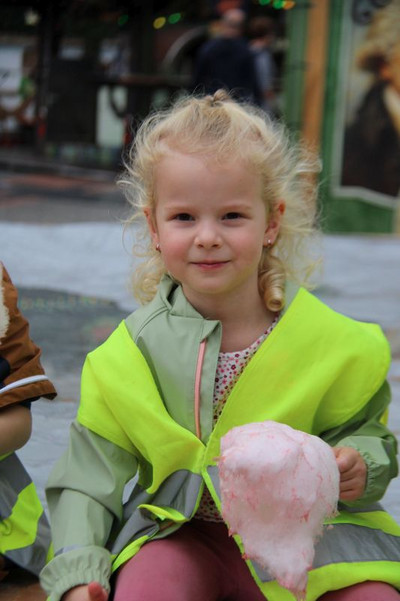 Auf dem Foto ist ein Zuckerwatte essendes Mädchen zu erkennen.