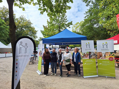 5 Mitarbeiterinnen vom Verein Lernen fördern stehen vor dem Infostand