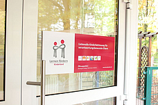 Eingangstür der Einrichtung mit dem Kinderlandlogo