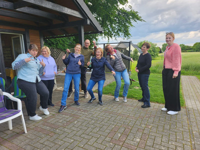 Mehrere Personen posieren für ein Gruppenbild bei einer Veranstaltung. 