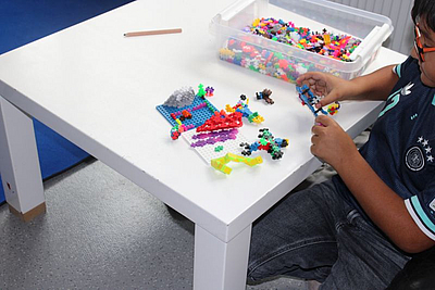 Ein Kind baut mit Puzzelsteinen. 