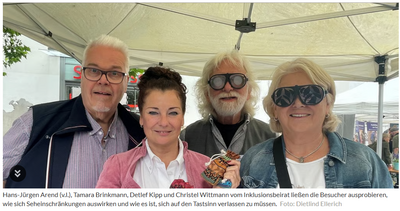 4 Menschen an einem Messestand unter einem Pavillon