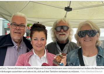 4 Menschen an einem Messestand unter einem Pavillon