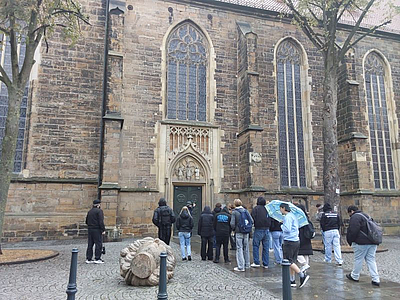 Eine Gruppe Personen steht vor der St. Dionysius Kirche