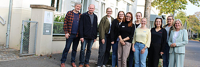 12 Menschen vor einem Gebäude