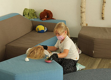 Ein Kind Veratztet eine Puppe