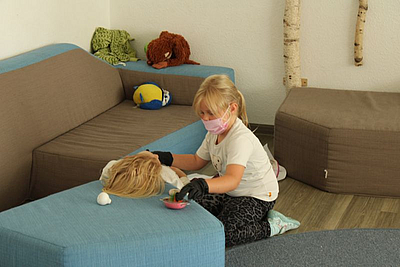 Ein Kind Veratztet eine Puppe
