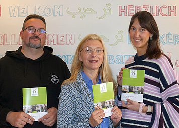 Drei Personen halten das neue 1x1 hoch. 